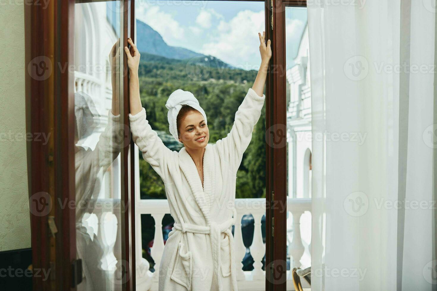 vrouw in een wit gewaad in de deuropening tegen de backdrop van de hotel bergen foto