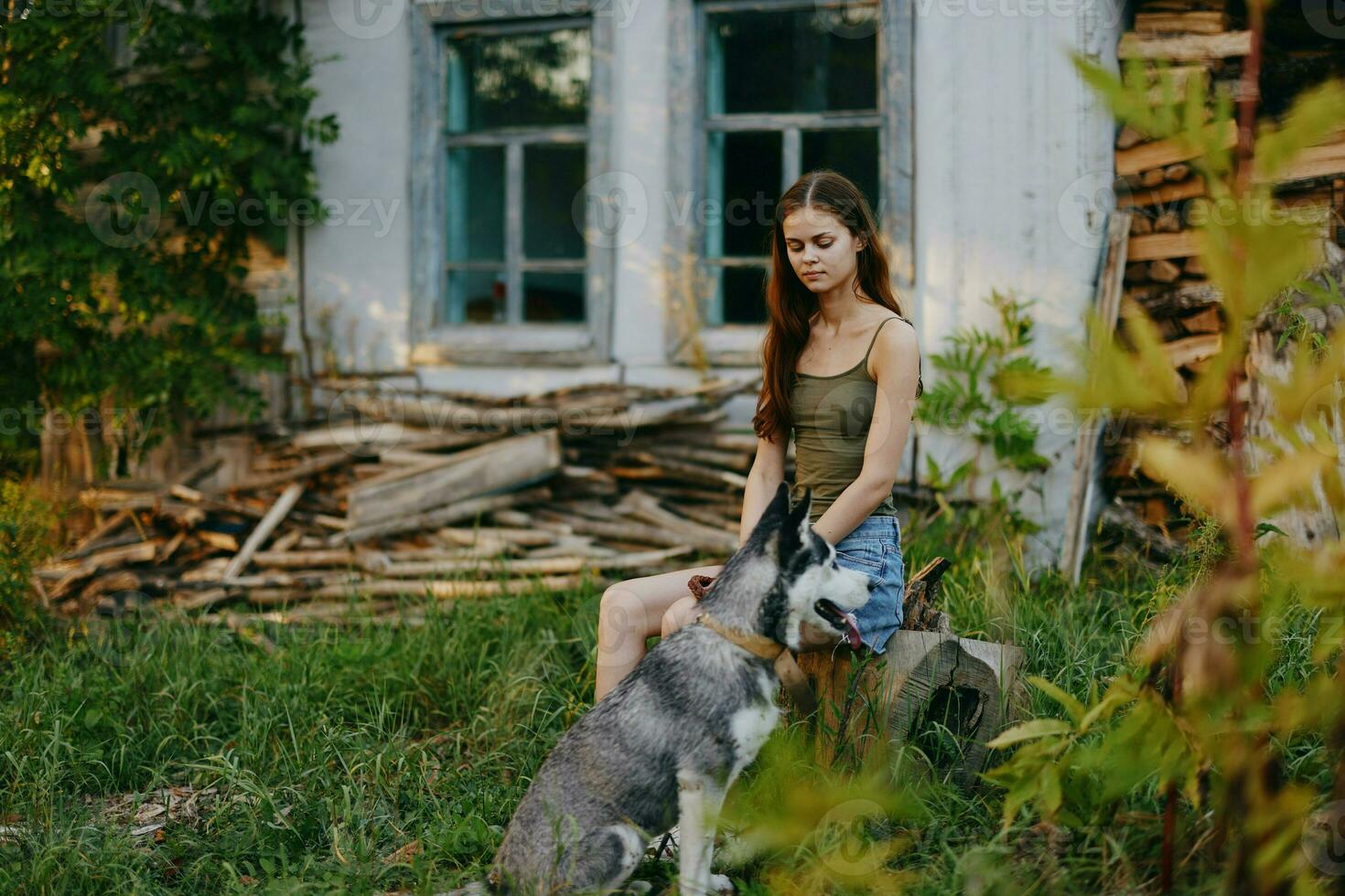 vrouw en haar schor hond gelukkig spelen buitenshuis in de park tussen de bomen glimlach met tanden in de herfst wandelen met haar huisdier foto