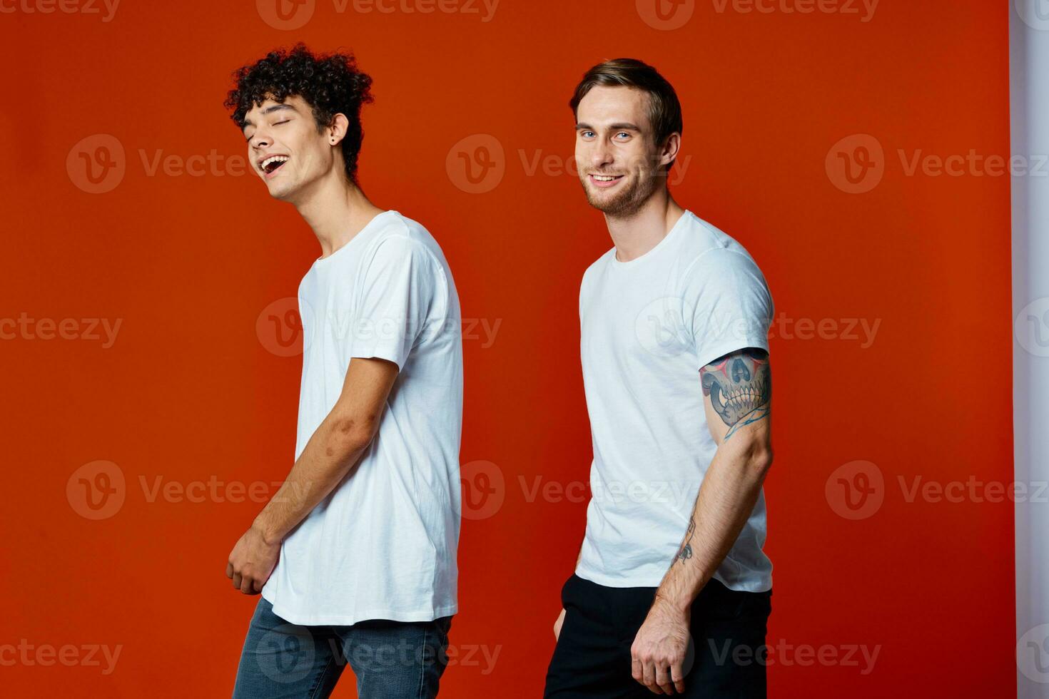 twee vrolijk mannen Aan t-shirts communicatie vriendschap rood achtergrond foto