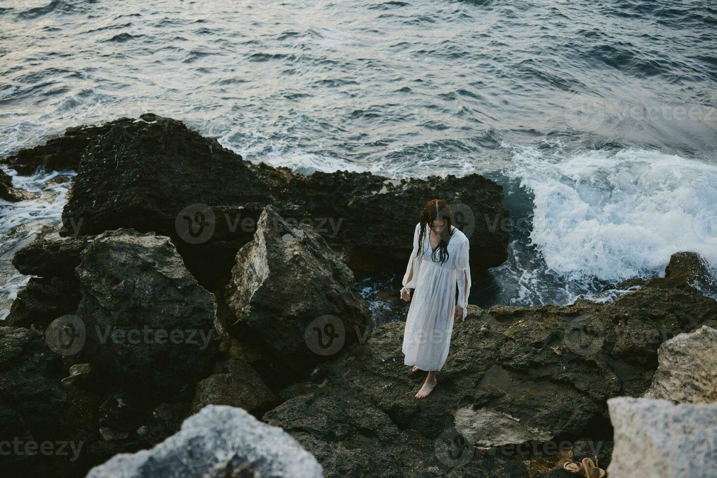 vrouw in wit jurk rotsen oceaan natuur reizen foto