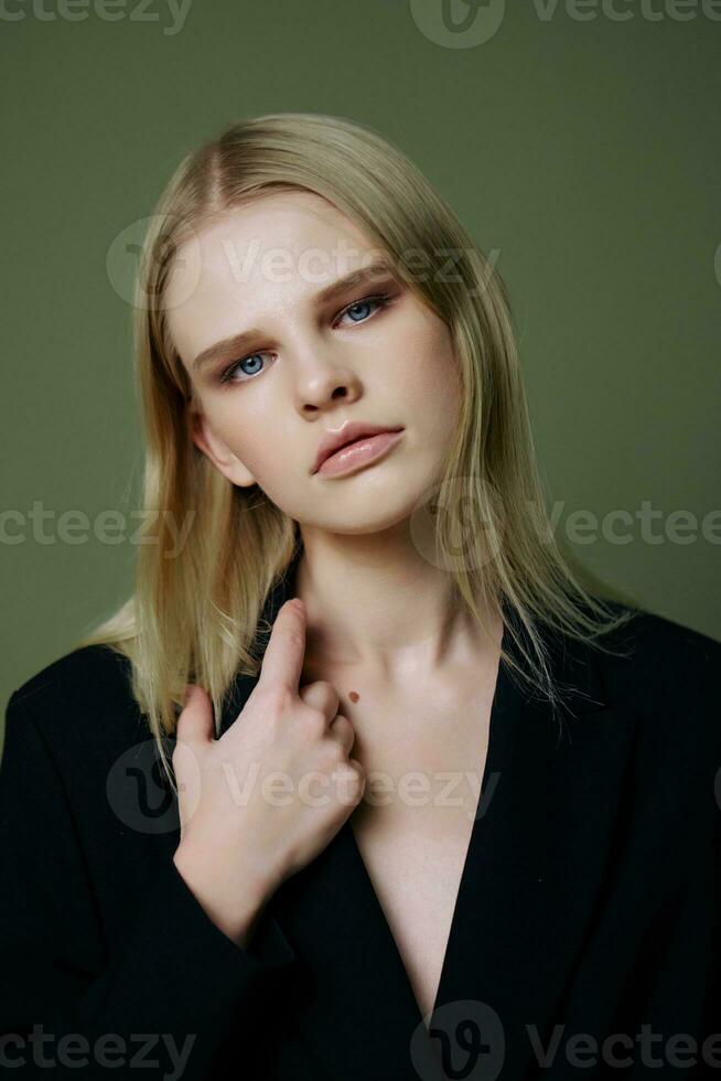 de hoofd portret van een charmant mooi meisje in een zwart jasje poses Aan een groen achtergrond in de studio. koel banier voor merken. koel aanbod voor ontwerp foto