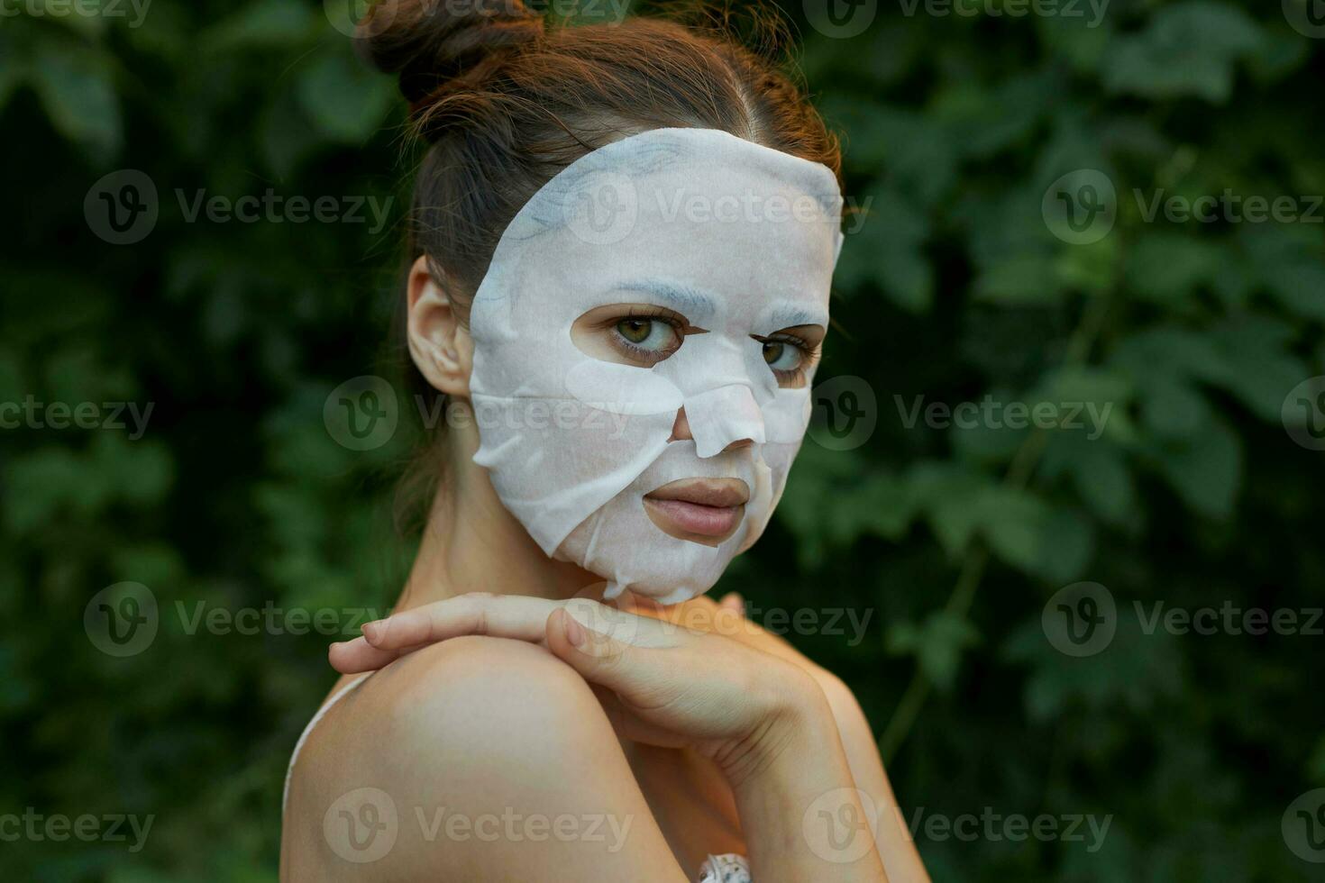 mooi hoor vrouw houdt hand- Aan schouder kant visie anti-veroudering masker kaal schouders bladeren in de achtergrond foto