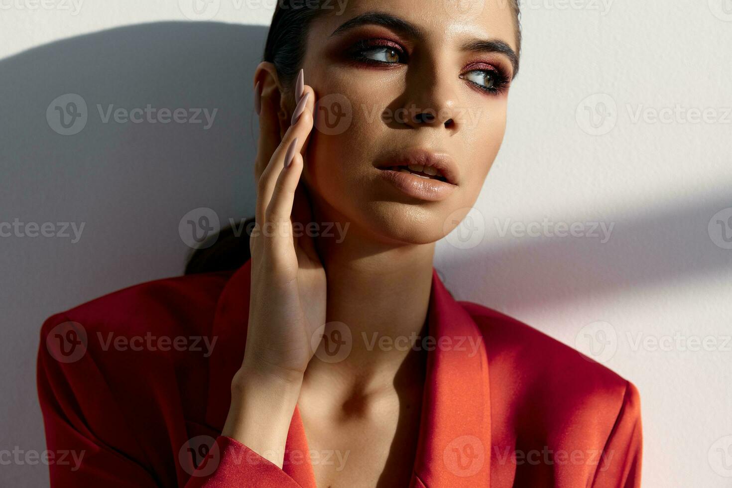 mooi vrouw met avond bedenken en in een rood jasje looks naar de kant foto