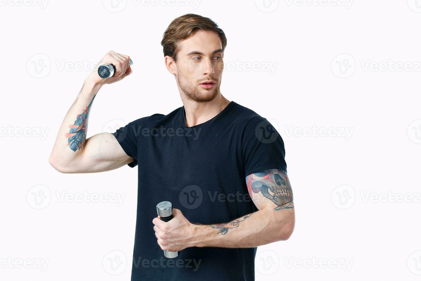 Mens in zwart t-shirt met tatoeëren Aan zijn arm en halters spier bodybuilder foto