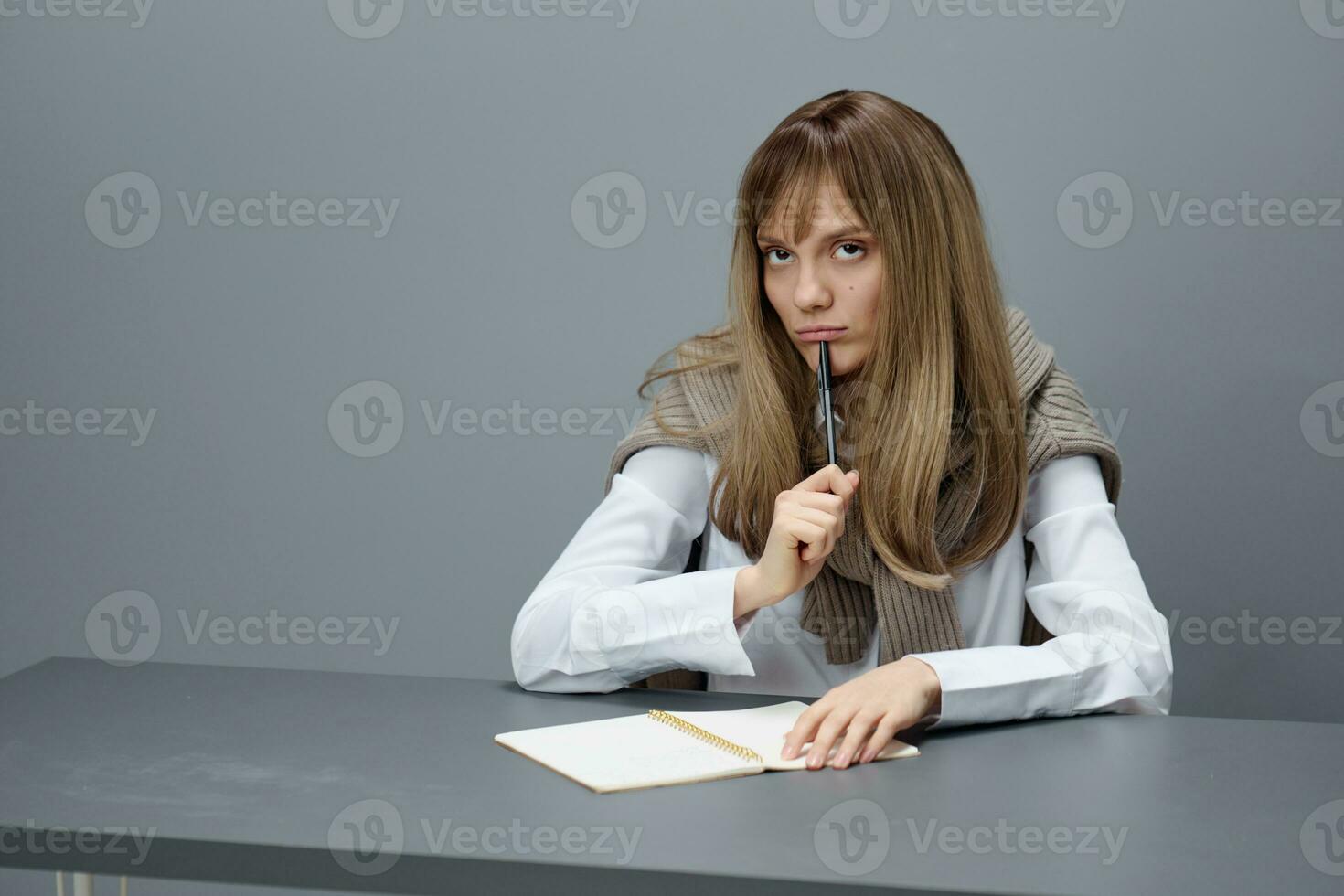 nadenkend verveeld jong blond journalist leerling dame freelancer in warm trui kijken terzijde zittend Bij werkplaats in grijs modern huis kantoor. onderwijs en carrière beroep concept. kopiëren ruimte foto