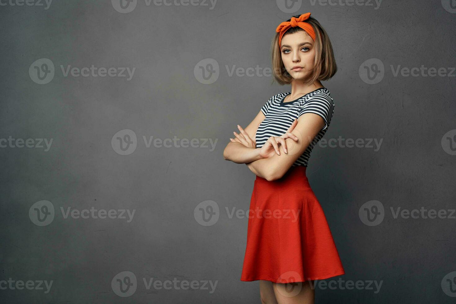 mooi modieus vrouw met oranje hoofdband rood rok poseren foto