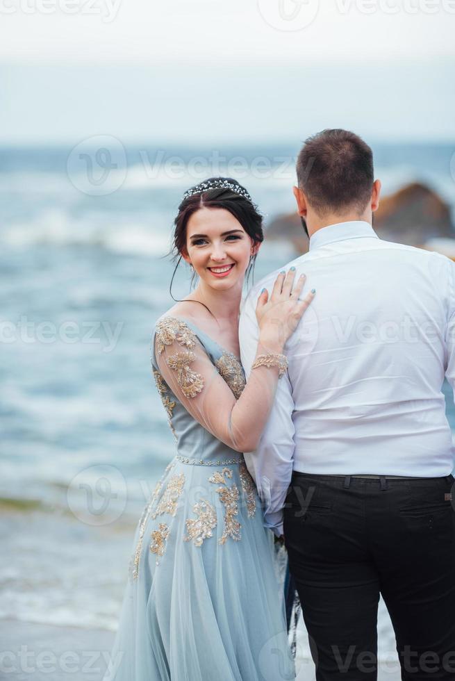 hetzelfde stel met een bruid in een blauwe jurk lopen foto