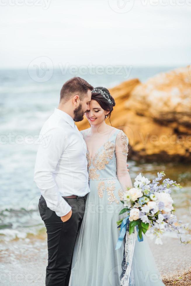 hetzelfde stel met een bruid in een blauwe jurk lopen foto