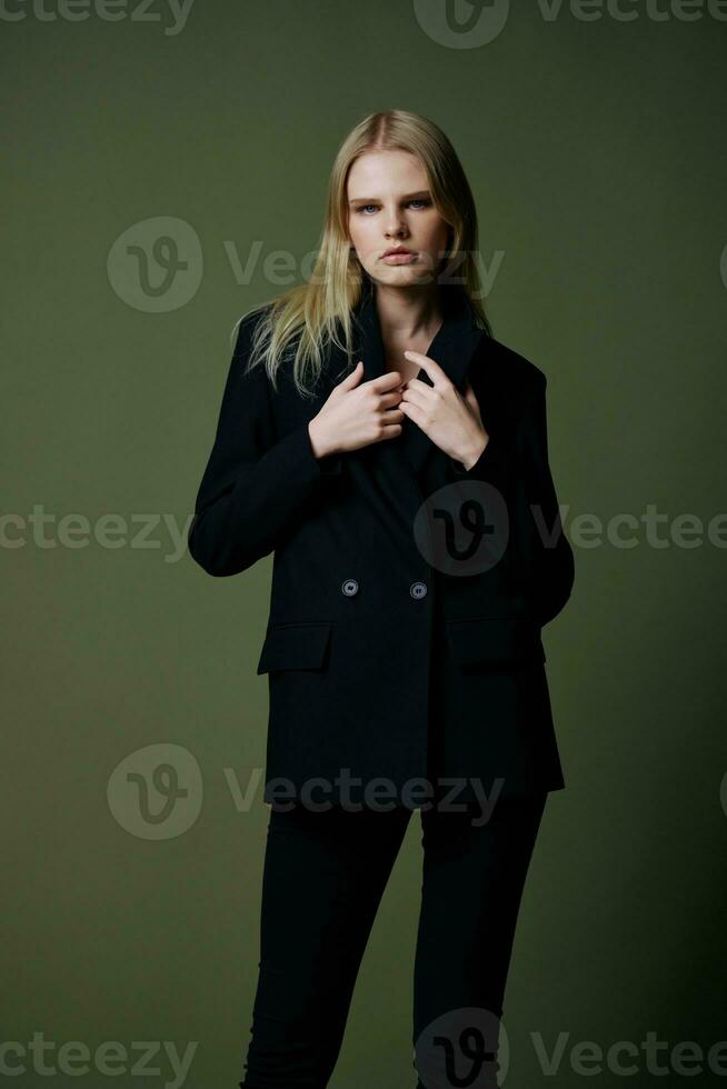 een concept voor marktplaatsen en kleding merken. volledige lengte portret van een blond Holding een jasje halsband poseren Aan een groen achtergrond in de studio foto