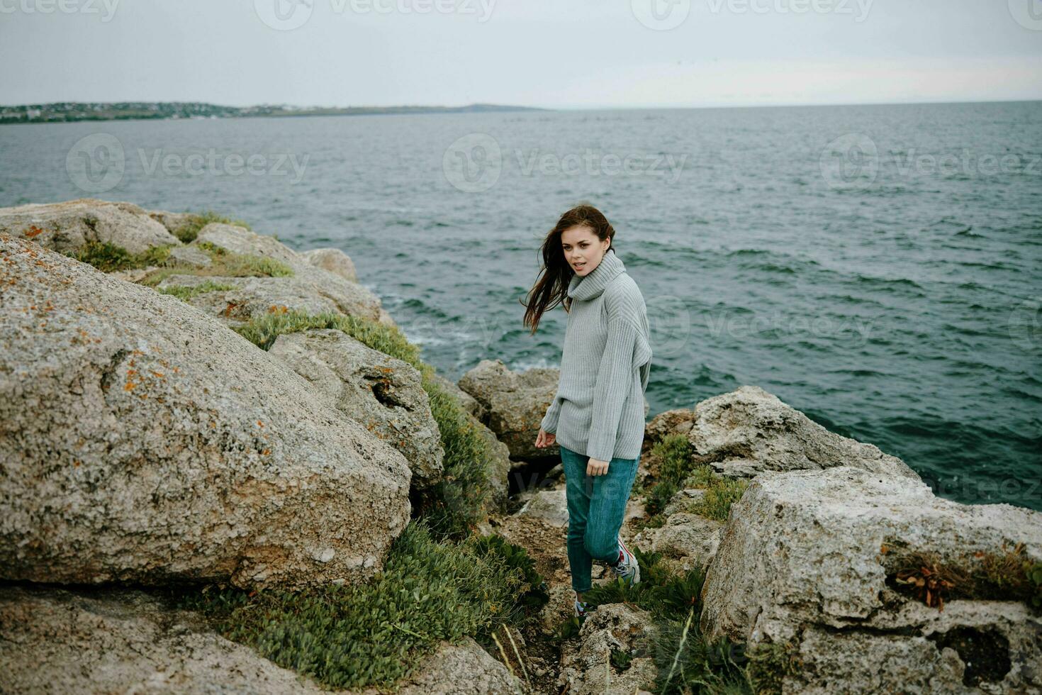 mooi vrouw lang haar- natuur rotsen kust landschap vrouw ontspannende foto