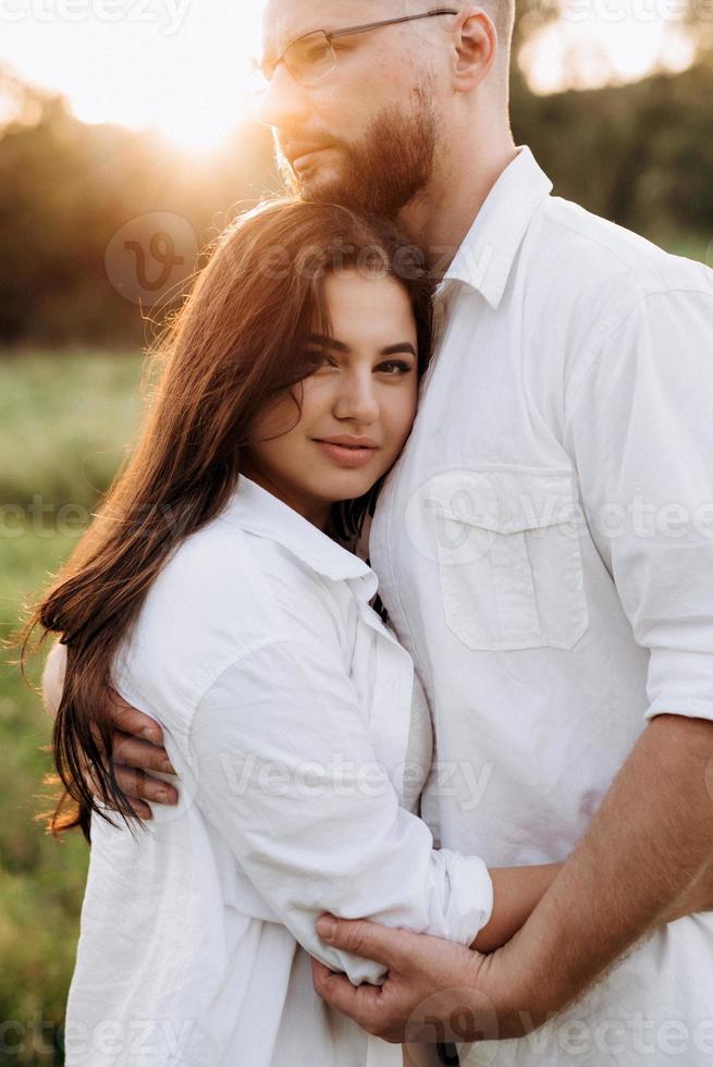 jong stel verliefd op een man met een baard en een meisje met donker haar in lichte kleren foto