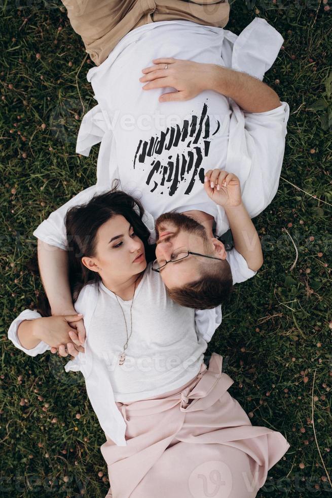 jong stel verliefd op een man met een baard en een meisje met donker haar in lichte kleren foto