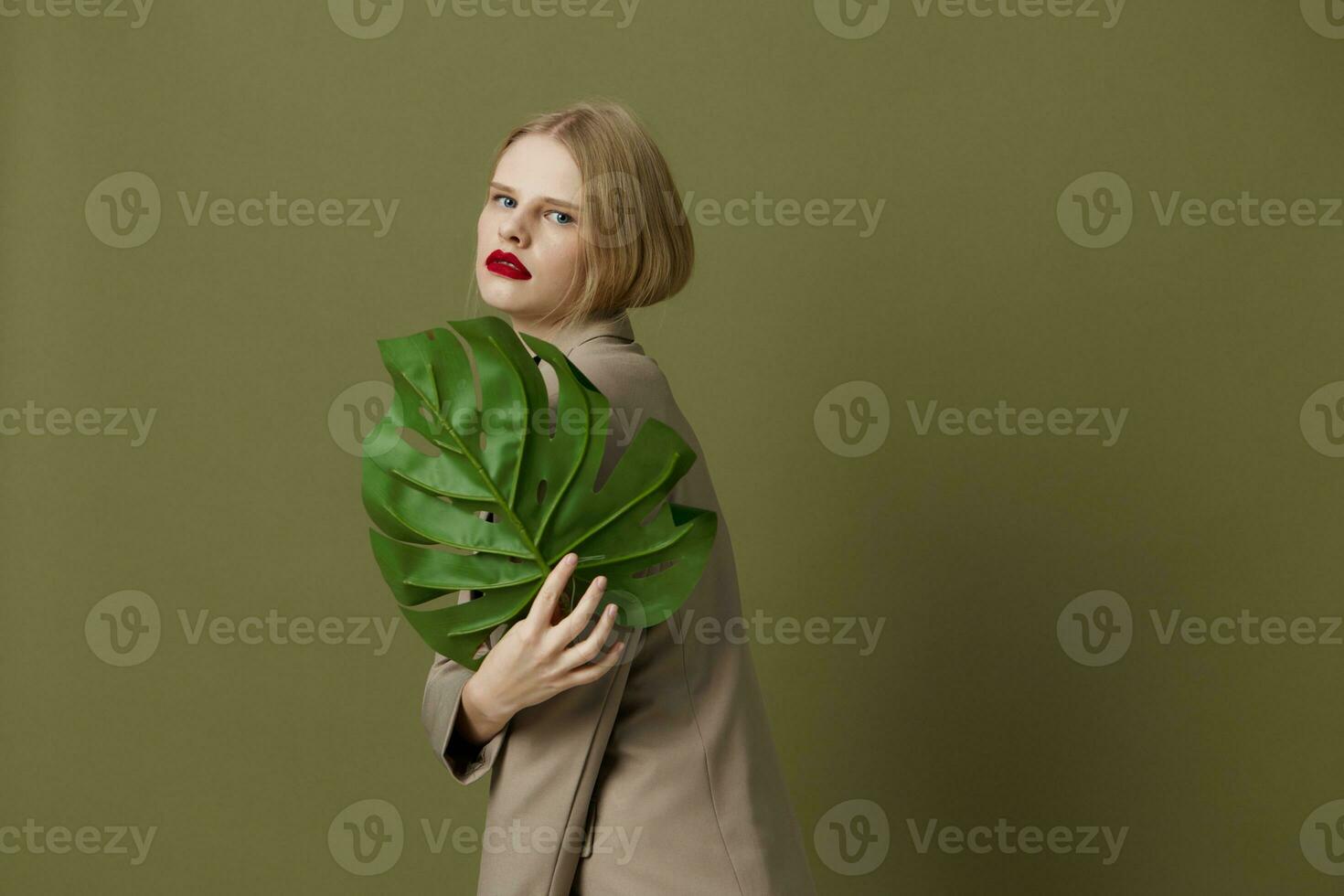 mooi vrouw groen palm blad jas helder bedenken groen achtergrond foto