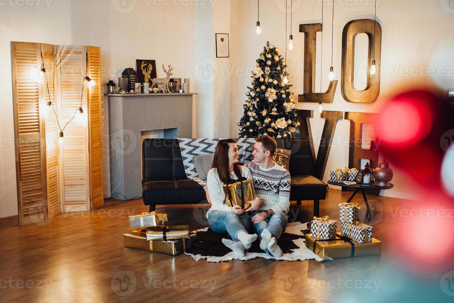 jongen en een meisje vieren samen het nieuwe jaar en geven elkaar cadeautjes foto