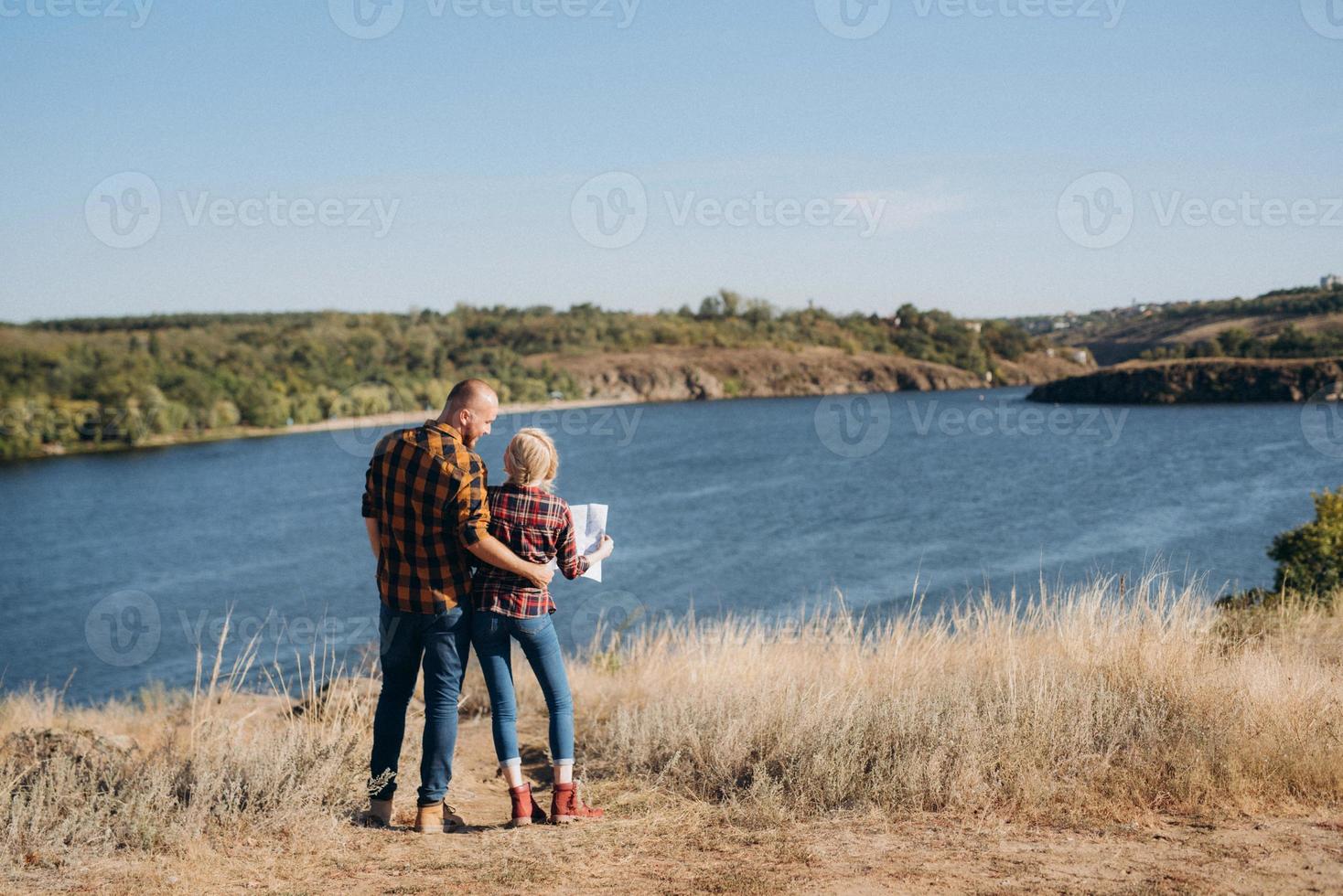 kale man met een baard en een blond meisje kijken naar de kaart en zoeken foto