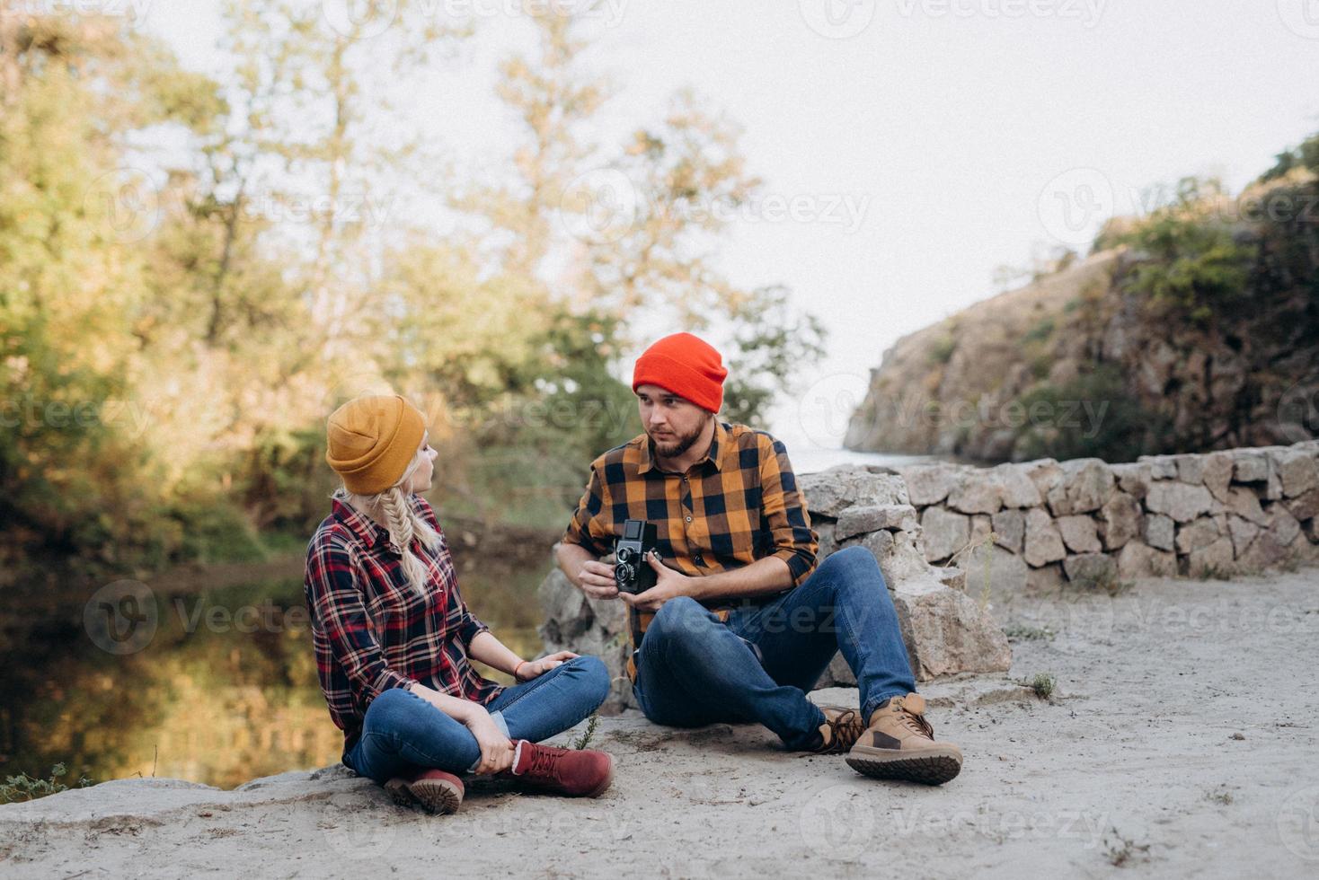 kale man met een baard en een blond meisje in lichte hoeden fotograferen met een oude camera foto