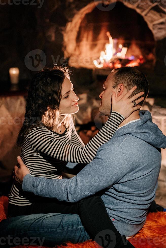 jongen en meisje zitten op de achtergrond van een brandende open haard foto