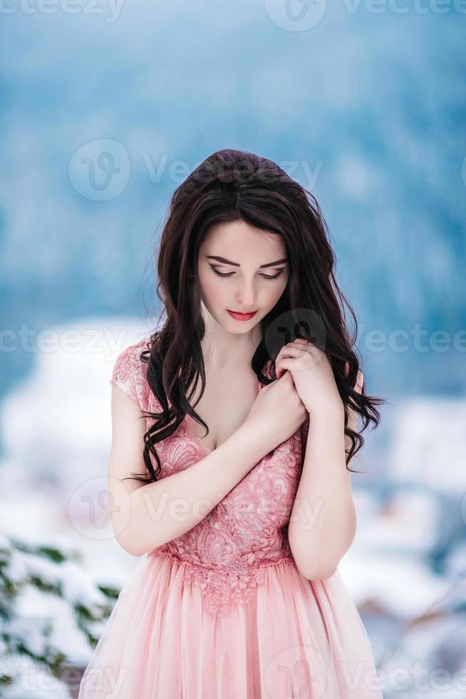 bruid met kastanjebruin haar blauwe achtergrond van de bergen van de winter foto