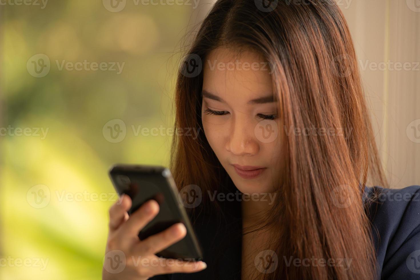 Aziatische zaken vrouw met behulp van mobiele telefoon in een kantoor foto