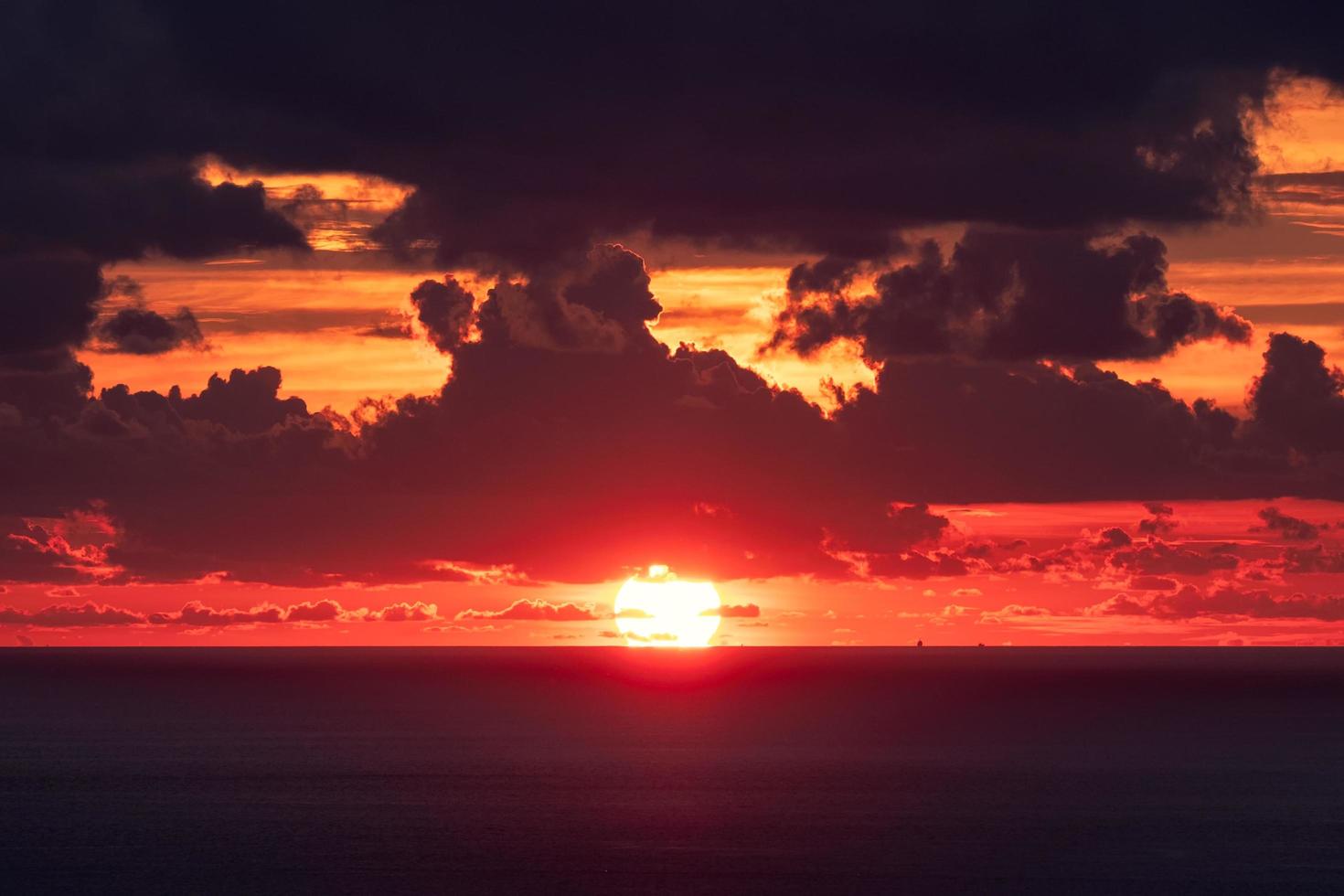 zonsondergang over horizon in tropische zee met bewolkt foto