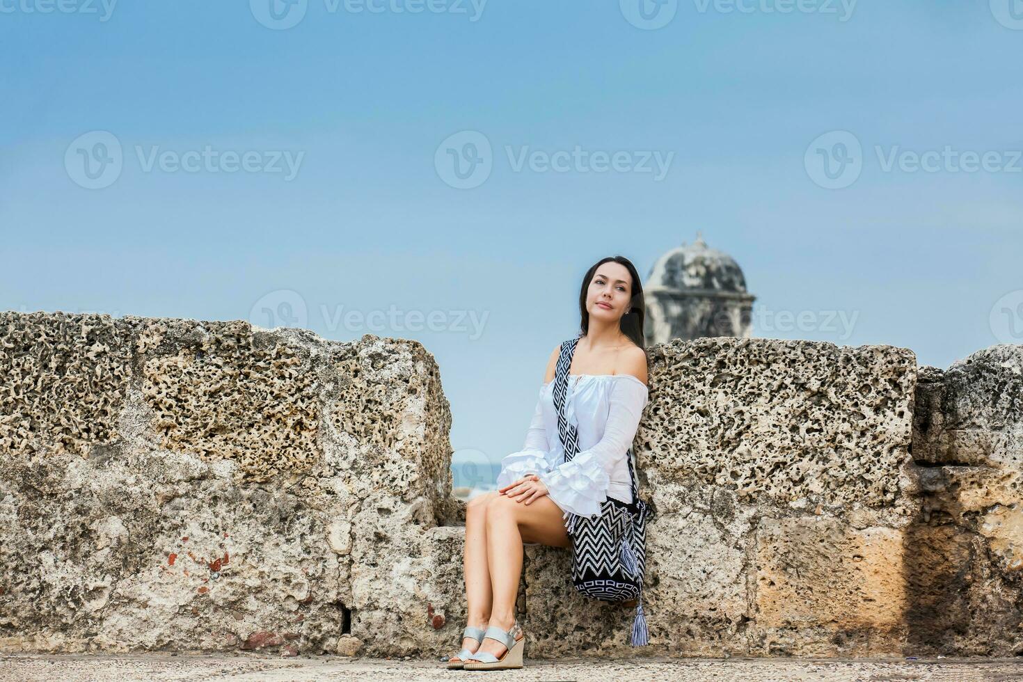 mooi vrouw Aan wit jurk zittend alleen Bij de muren omgeving de koloniaal stad van Cartagena de india's foto