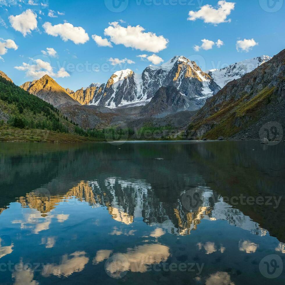 mooi avond landschap met gletsjer reflectie in water oppervlakte van berg meer. besneeuwd berg weerspiegeld in Doorzichtig water van glaciaal meer. sneeuw Aan rots weerspiegeld in berg meer. foto