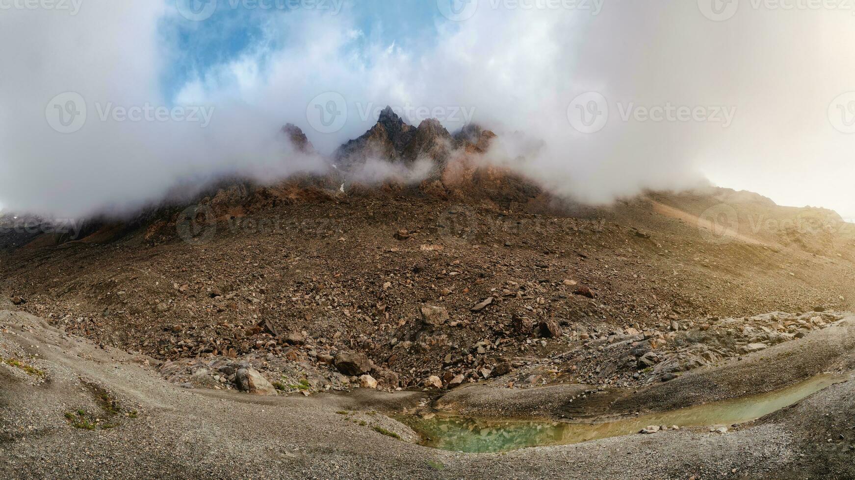 sfeervol ochtend- berg landschap. panoramisch landschap in hooglanden. scherp pieken van de rotsen kijken uit van de wolken en ochtend- mist. foto