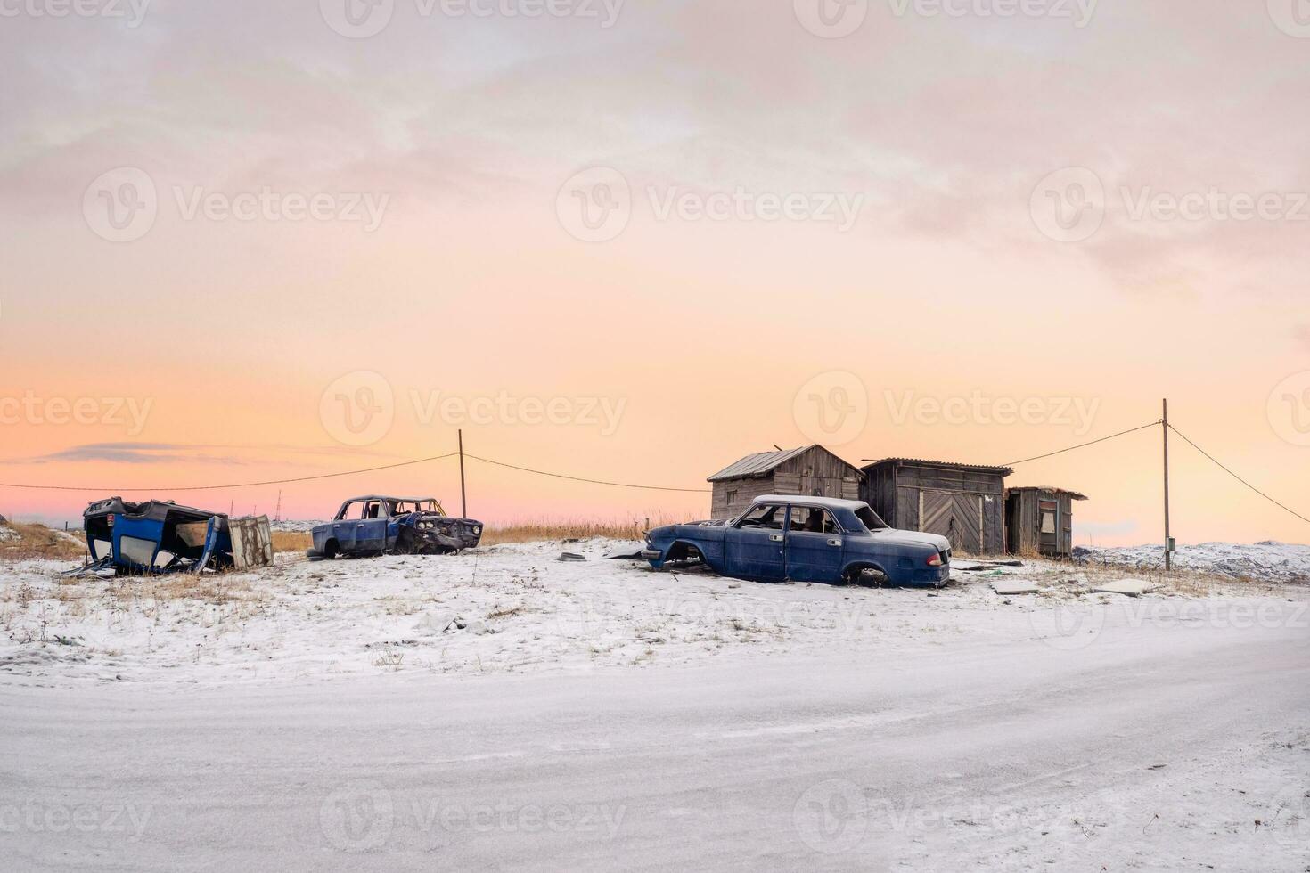 arctisch avond landelijk landschap. oud gedemonteerd auto Bij de garages in authentiek dorp van teriberka. kola schiereiland. foto