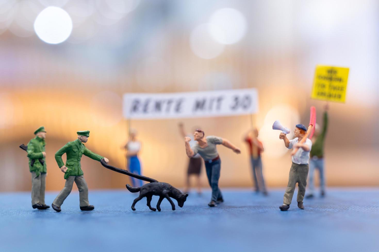 miniatuurmensen, demonstranten die borden vasthouden, hun hand opsteken voor revolutie foto