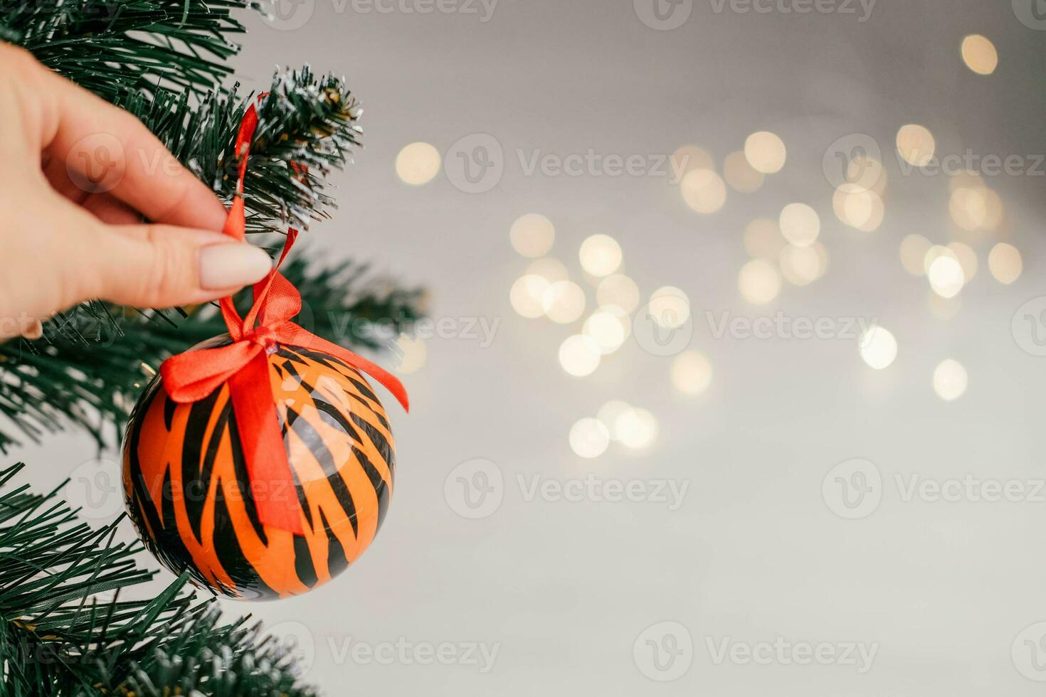 Kerstmis ballen geschilderd net zo tijger strepen Aan Kerstmis boom met een guirlande. 2022 is een jaar van de tijger. gelukkig nieuw jaar . symbool van jaar maan- Chinese kalender tijger Aan Kerstmis bal . kopiëren ruimte. foto