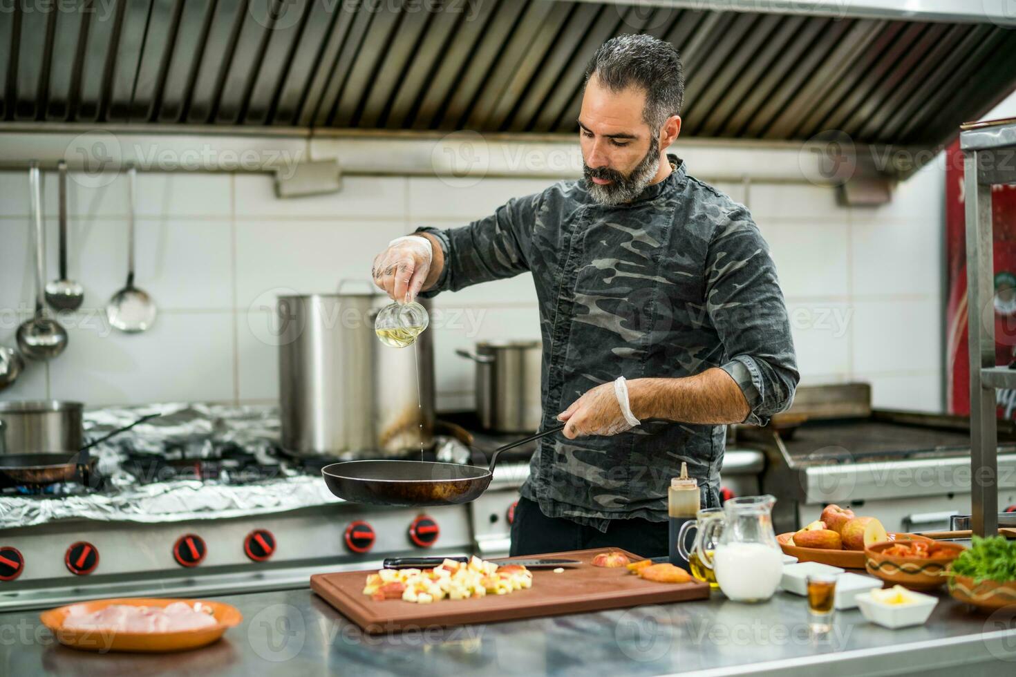 een chef is voorbereidingen treffen een maaltijd in de restaurants keuken. foto