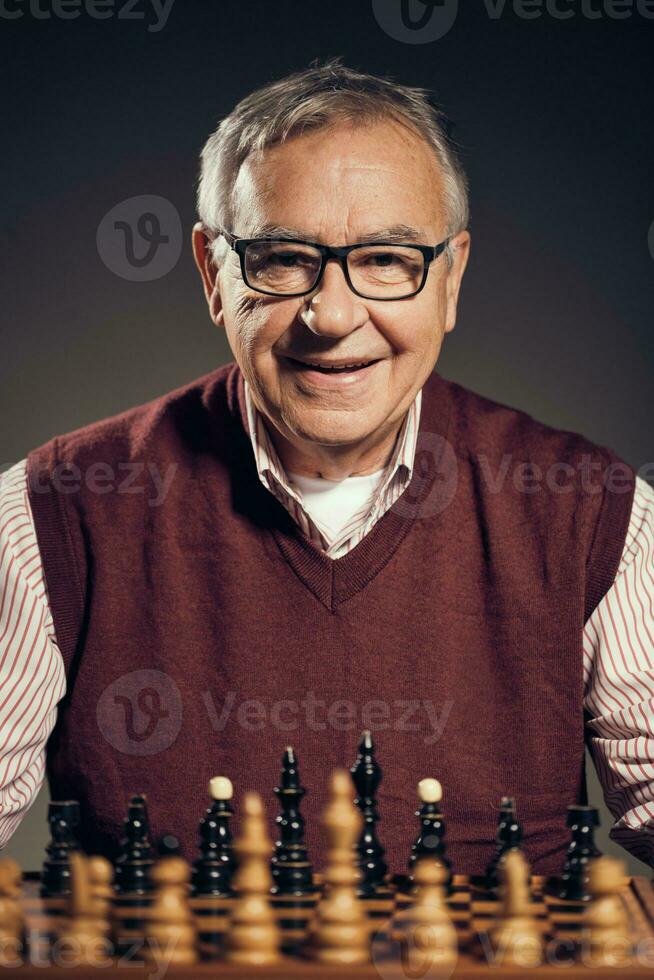 een senior Mens spelen schaak foto