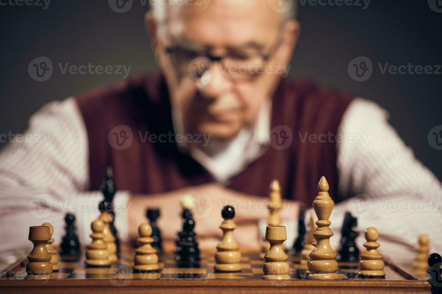 een senior Mens spelen schaak foto