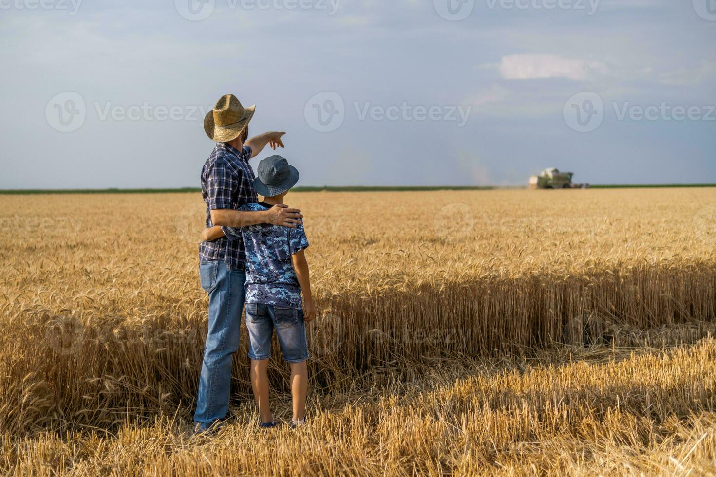 vader en zoon zijn staand in hun tarwe veld- foto