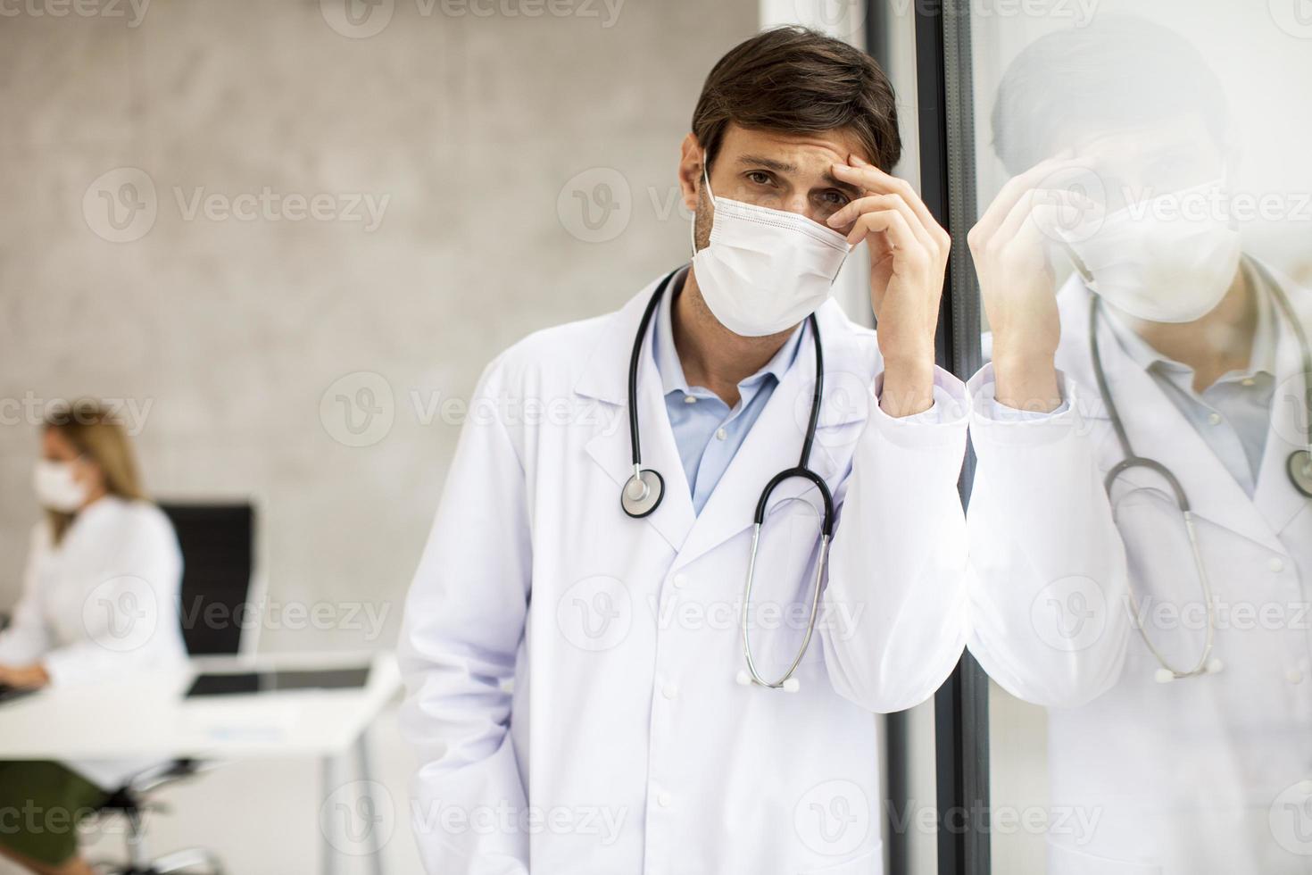 dokter kijkt bezorgd terwijl hij een masker draagt foto