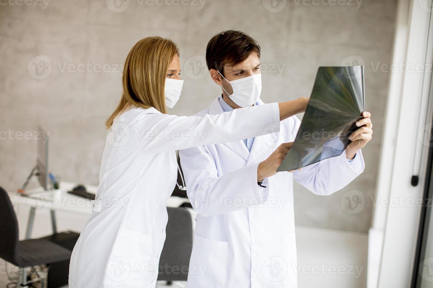 gemaskerde artsen die een röntgenfoto onderzoeken foto