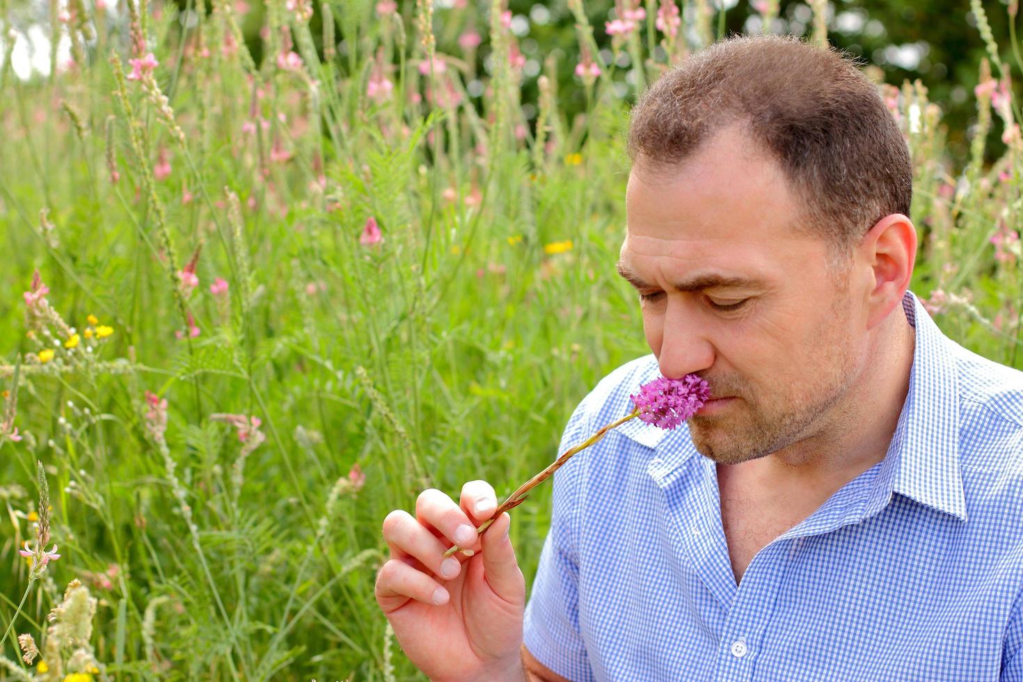 man die een bloem ruikt foto