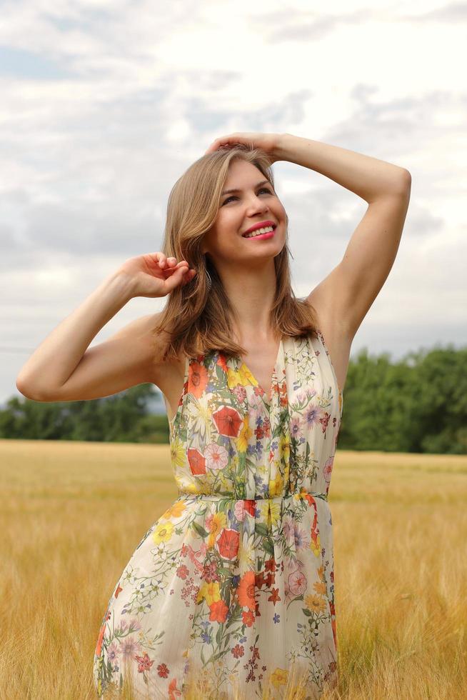gelukkige vrouw in een jurk in een veld foto