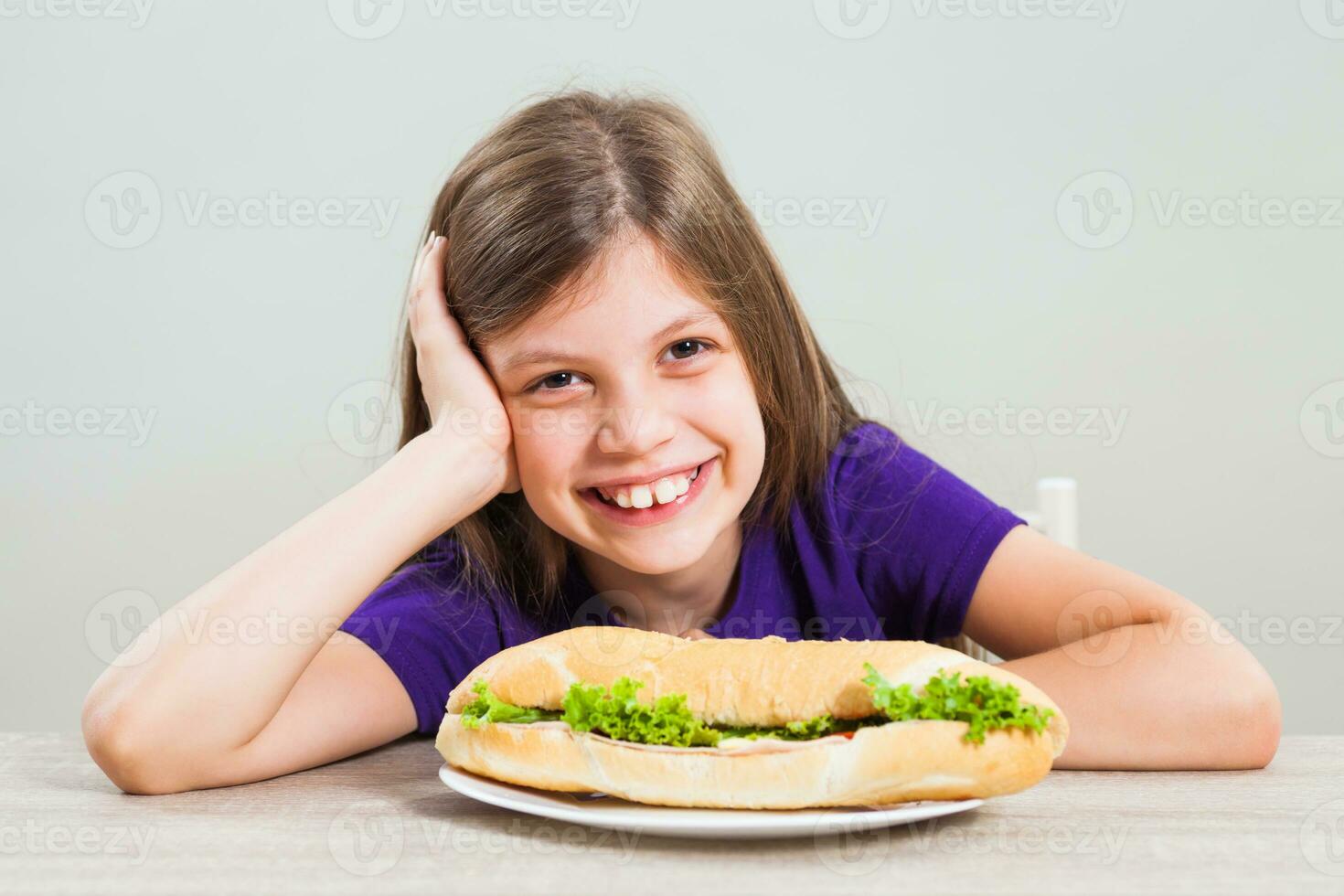 een meisje aan het eten een belegd broodje foto
