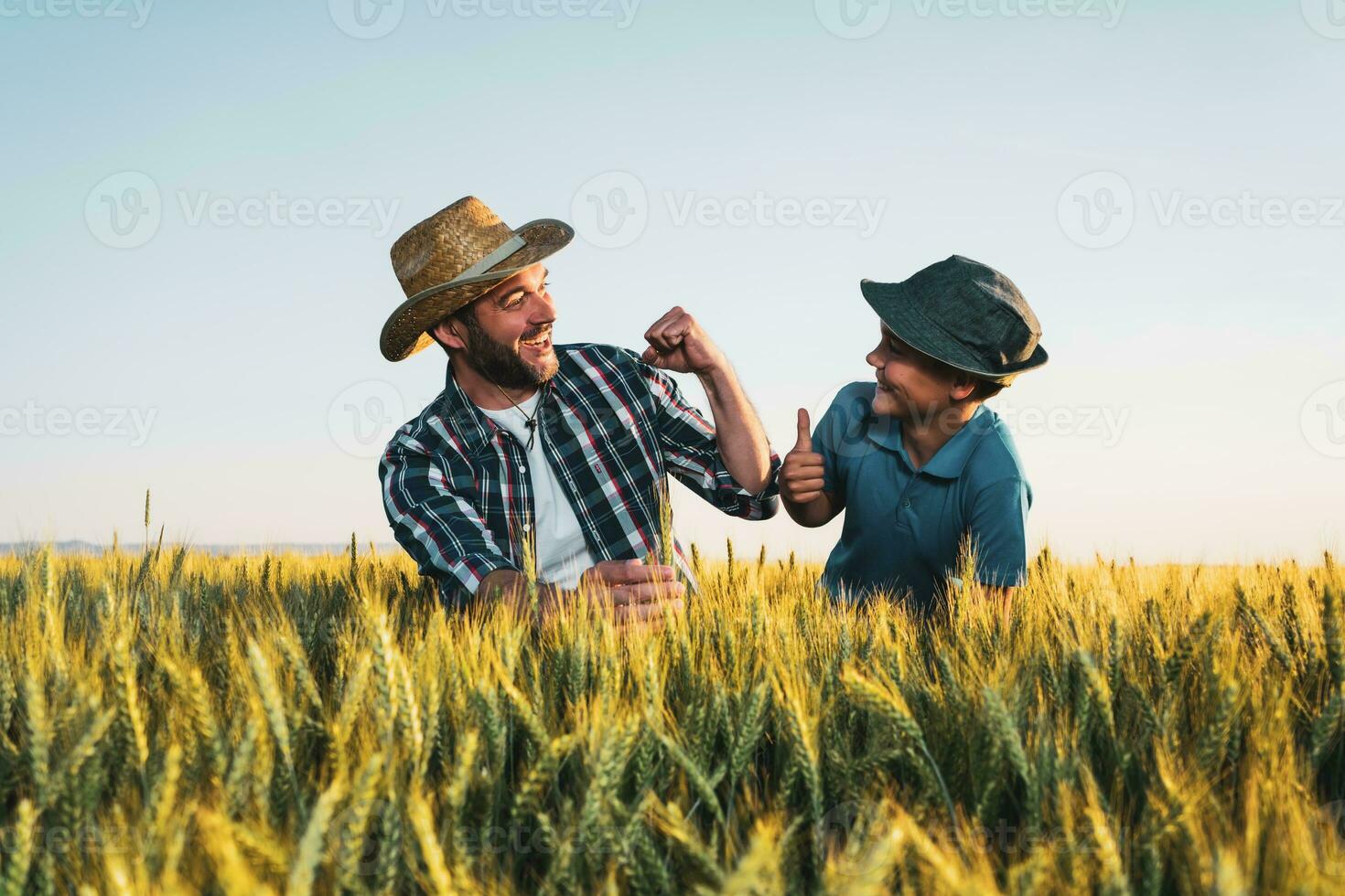 vader en zoon staand in een tarwe veld- foto