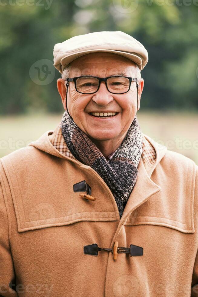 buitenshuis portret van een gelukkig senior Mens in winter jas foto