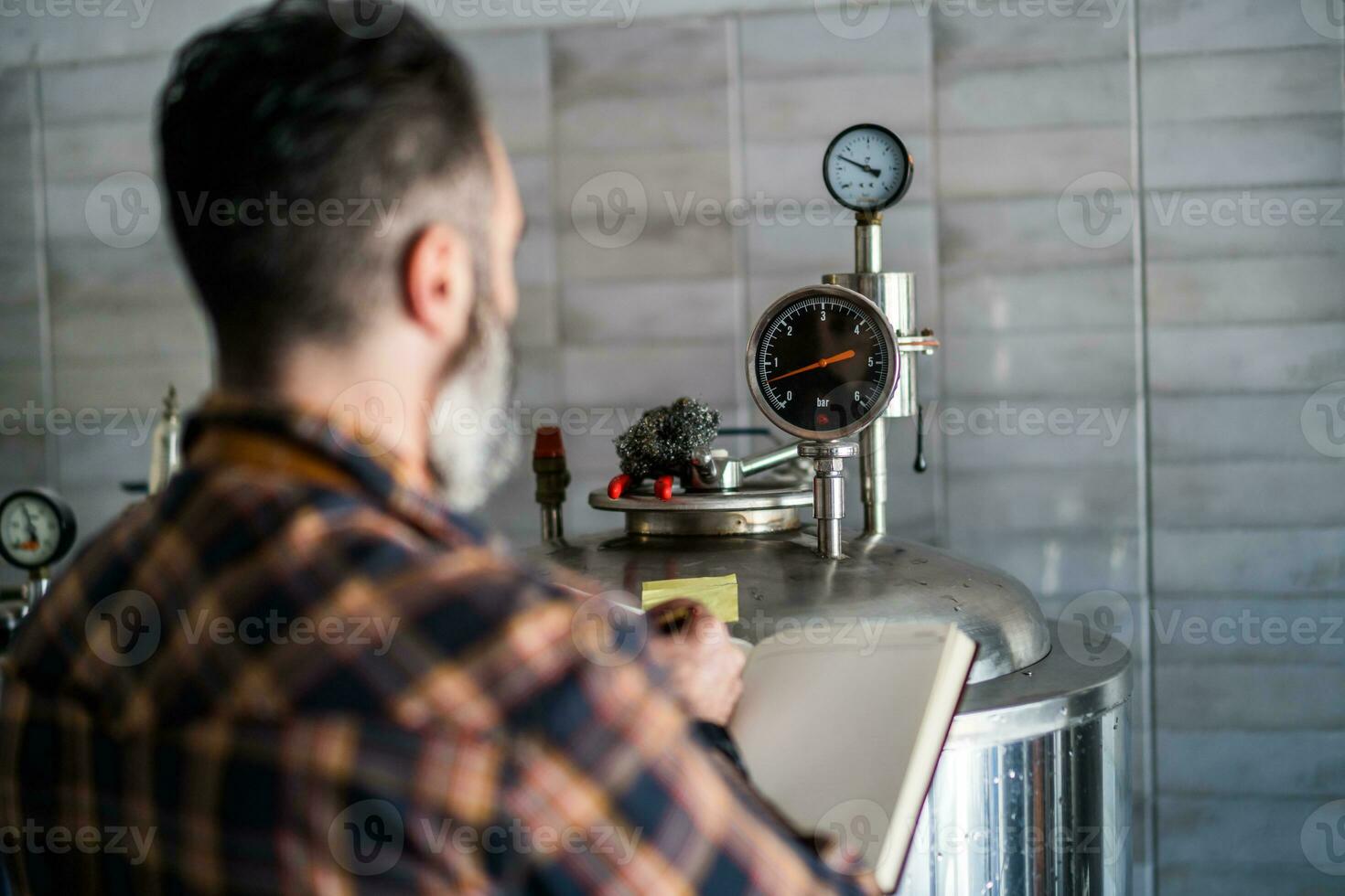 een brouwerij meester toezien op de bier productie werkwijze foto