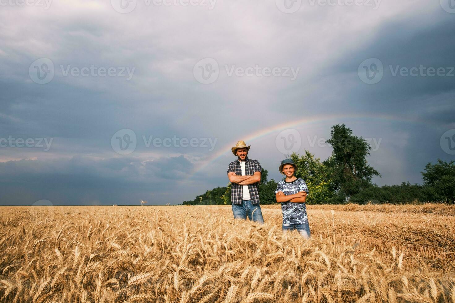 vader en zoon zijn staand in hun tarwe veld- foto