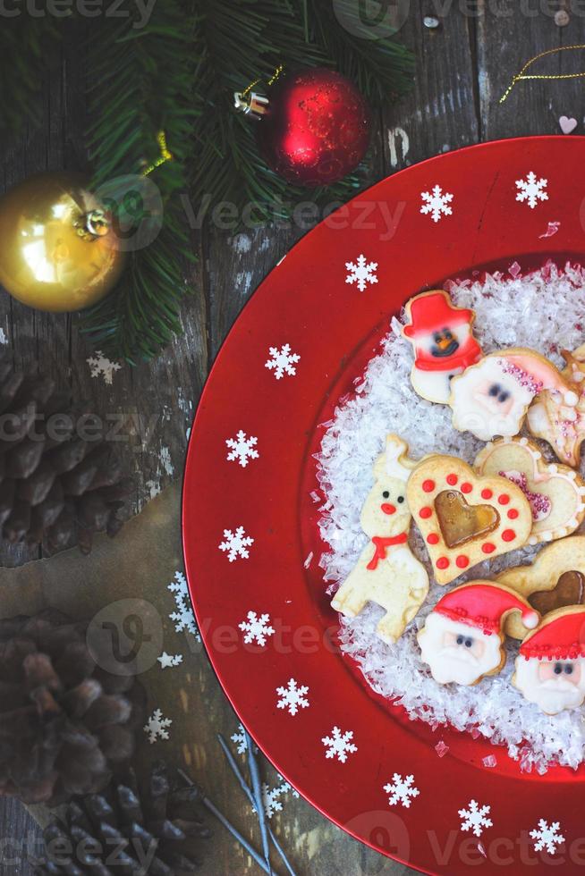 kerstkoekjes op rode feestelijke plaat met sneeuwvlokken foto