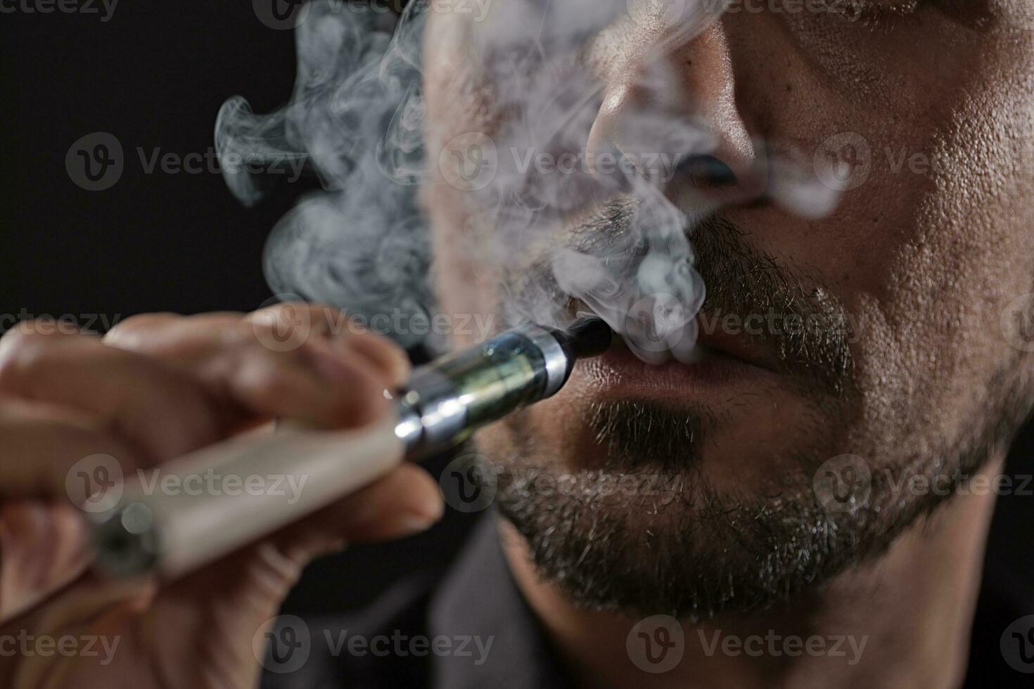 een Mens roken een elektronisch sigaret foto