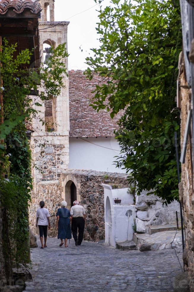 mensen slenteren in de pittoreske smalle straatjes van het oude Kakopetria in het Troodos-gebergte Cyprus met een meisje dat in de verte loopt foto