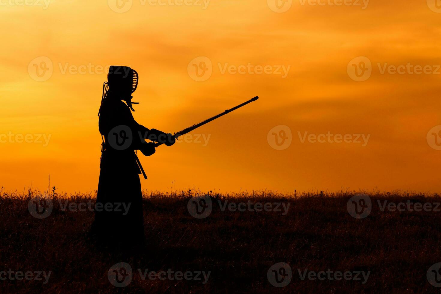 silhouet van kendo vechter met shinai over- de zonsondergang foto