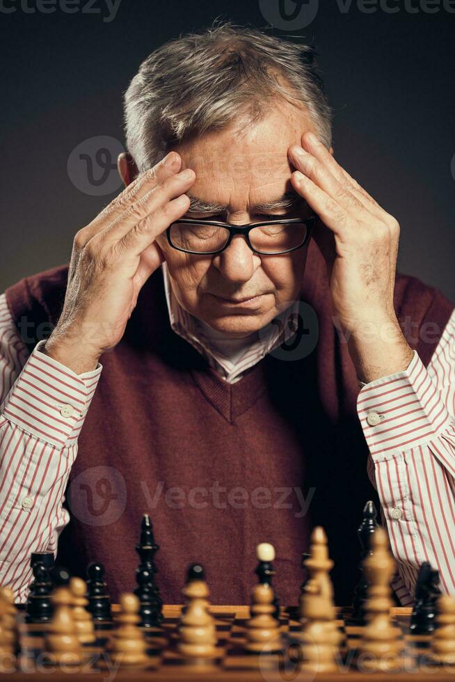 een senior Mens spelen schaak foto