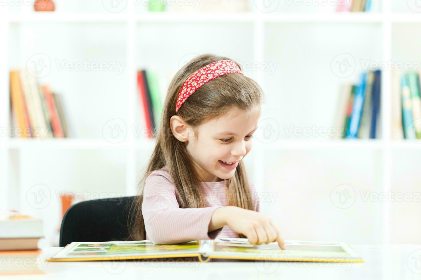 een weinig meisje aan het studeren foto