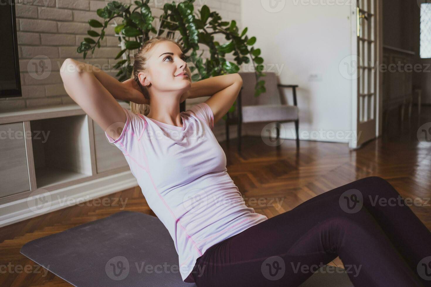 jong vrouw aan het doen fysiek opdrachten Bij huis foto